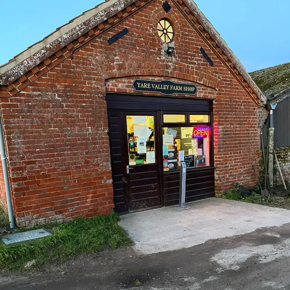 Exterior of Yare Valley Farm Shop with open sign and brick barn frontage